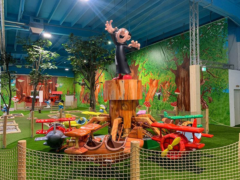 Das Flugzeug-Ringelspiel Wolkenflitzer mit bunten Doppeldeckern, oben auf dem Baumstamm steht Gargamel. Foto: © Wolfgang DeMarco / ZIBINGU